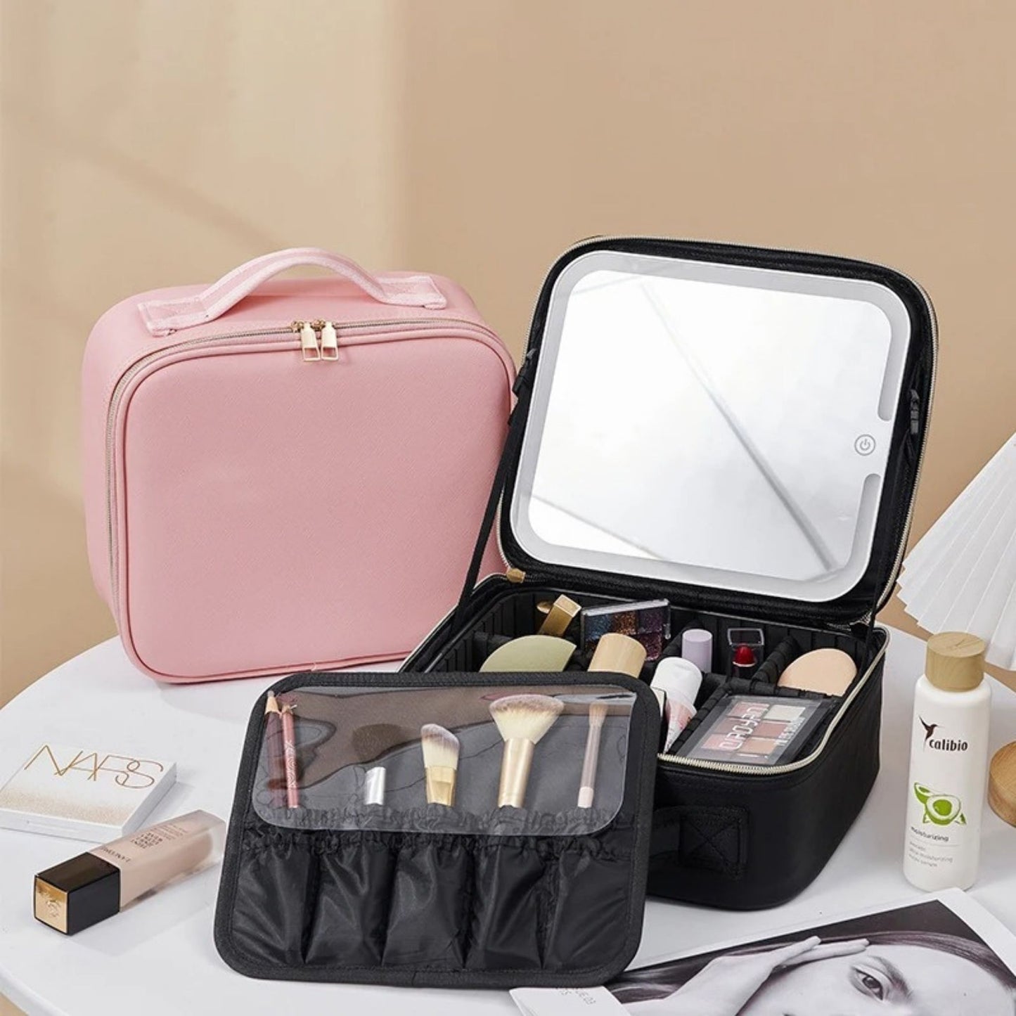 ILLUMake Carry Case on a table - showing the pink variant closed & the black variant open full of makeup - Beauty Box Shop